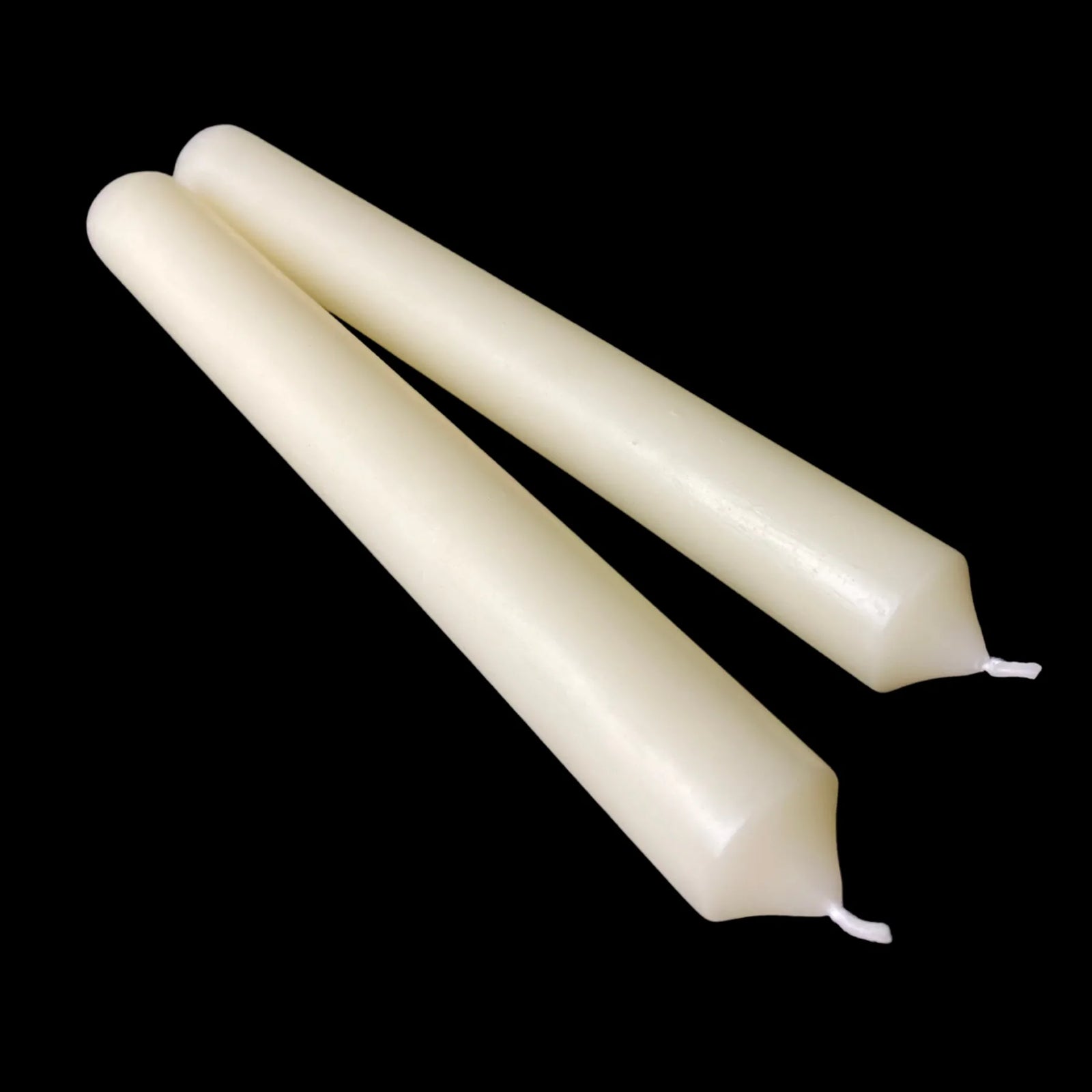 Two white dripless beeswax tapers laid on black, 1 inch diameter, honey scented