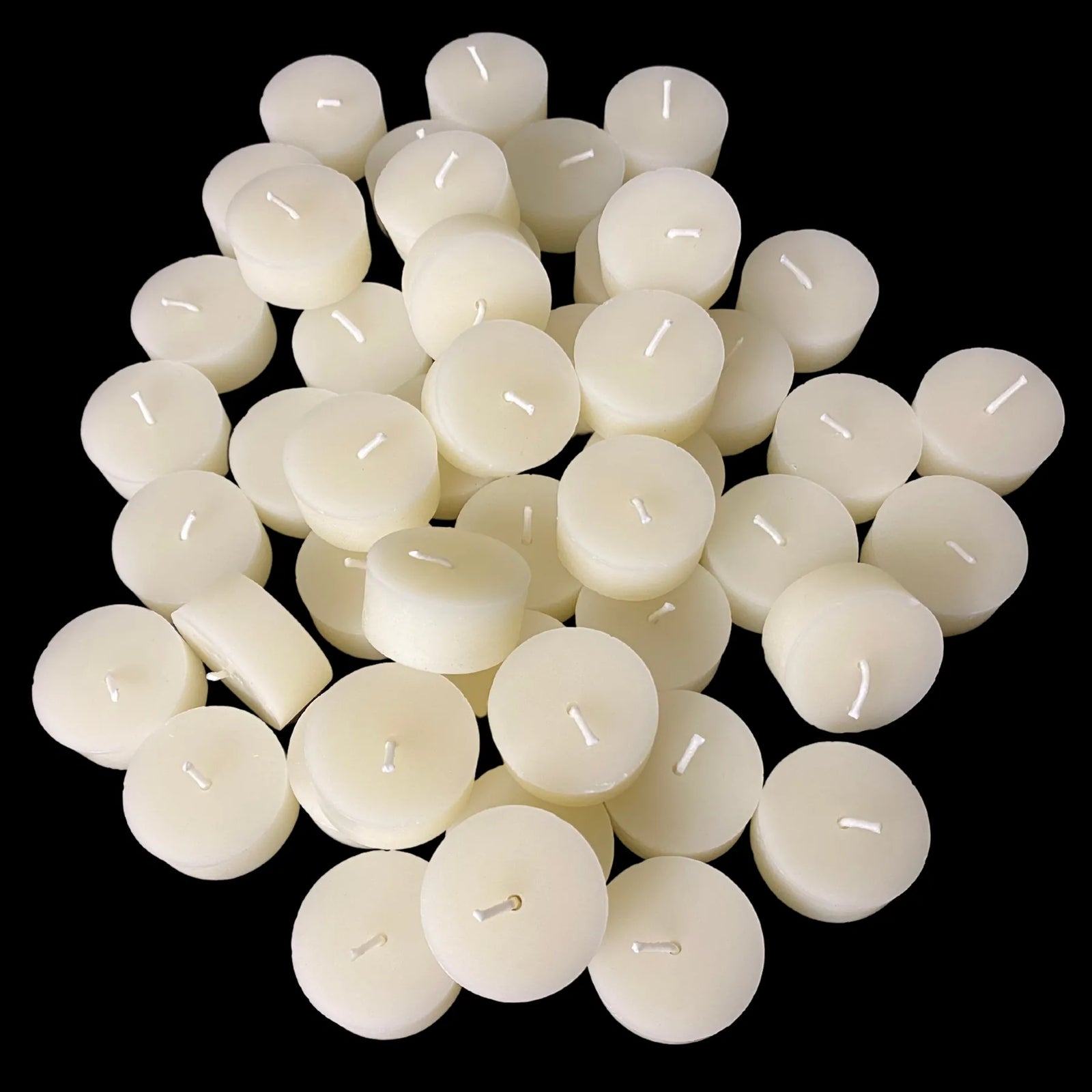 White beeswax tea lights in large quantity showing cotton wicks, 1.43" wide