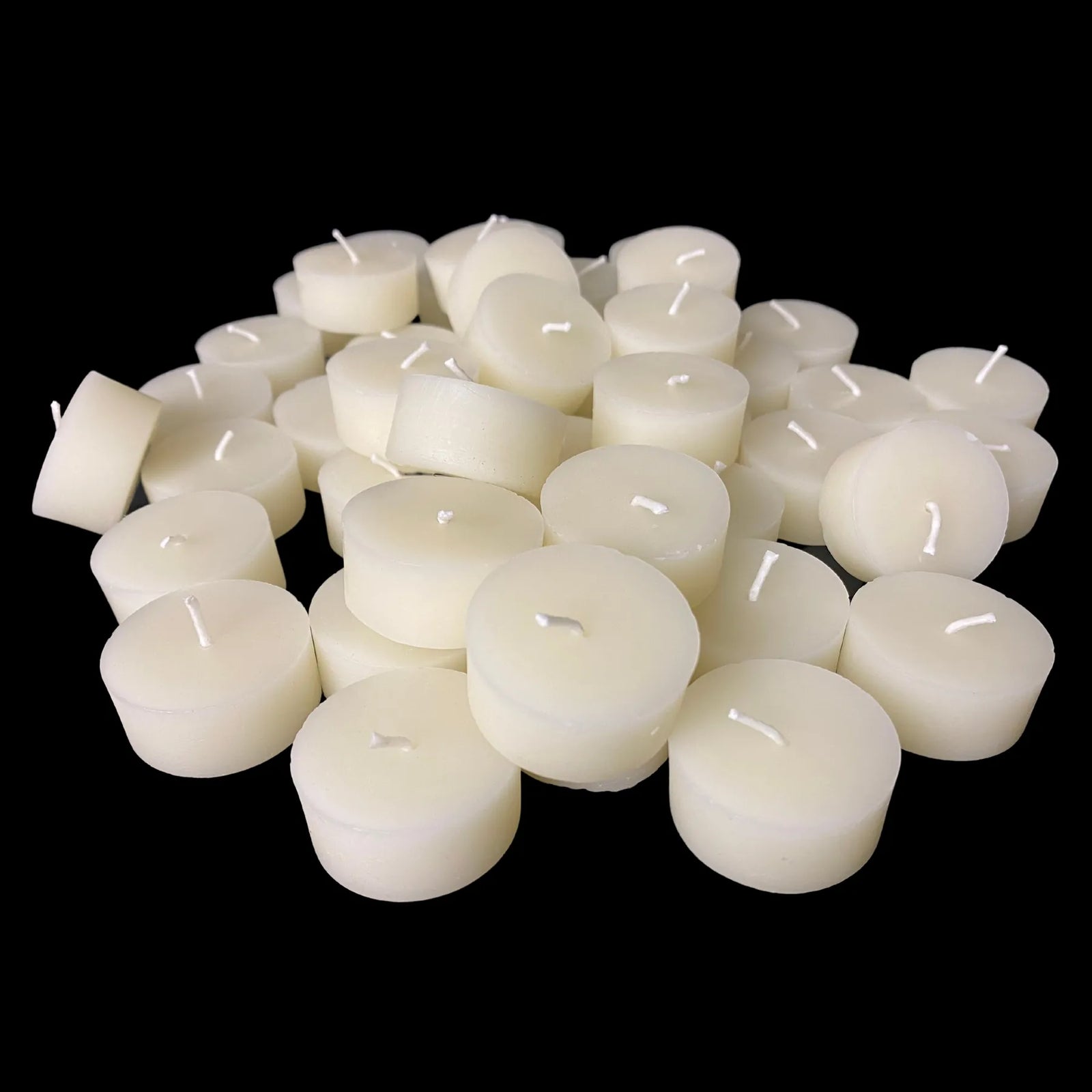 Small stack of white beeswax tea lights showing cotton wicks, 1.43 inch