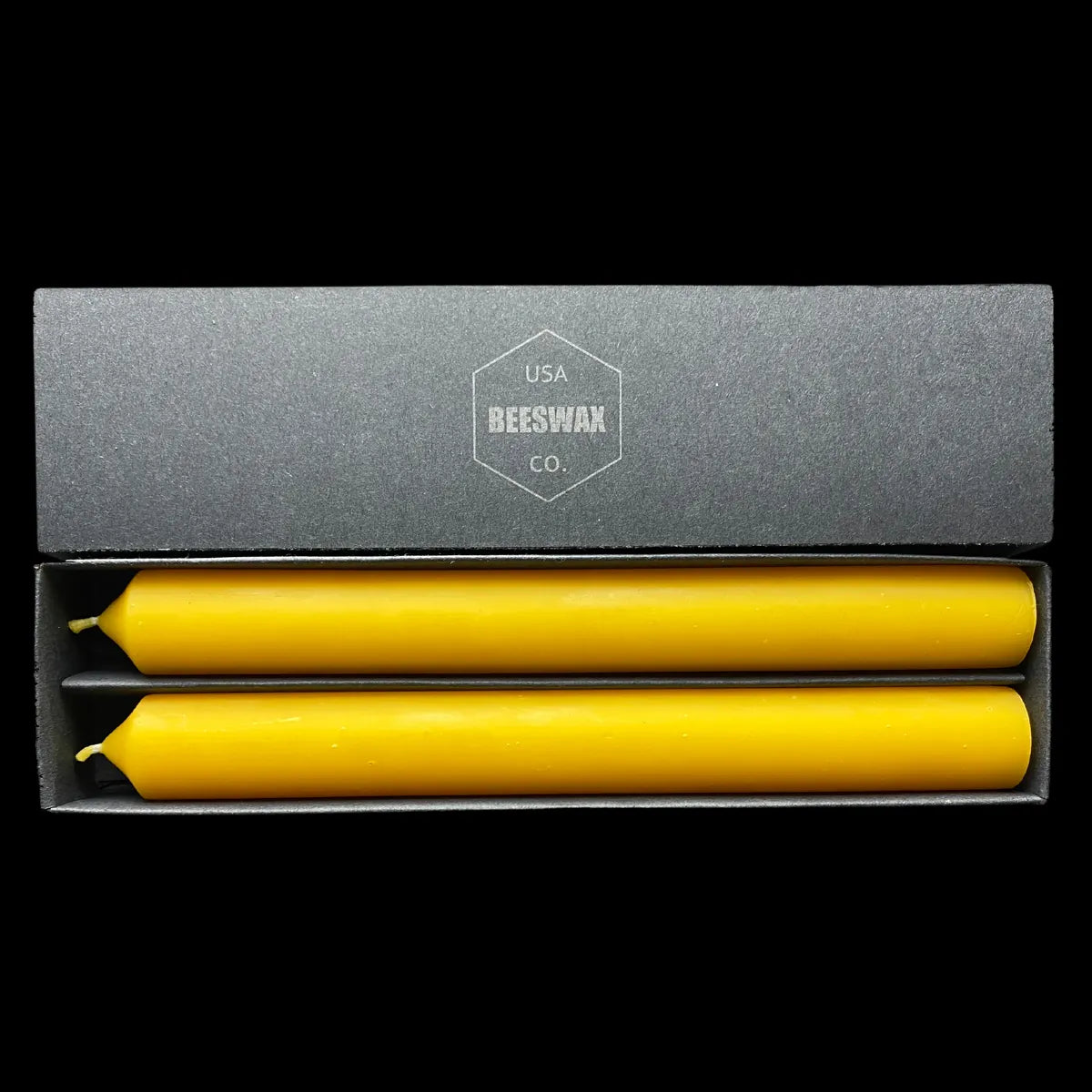 Hand poured yellow beeswax tapers in an open branded gift box, 1" thick