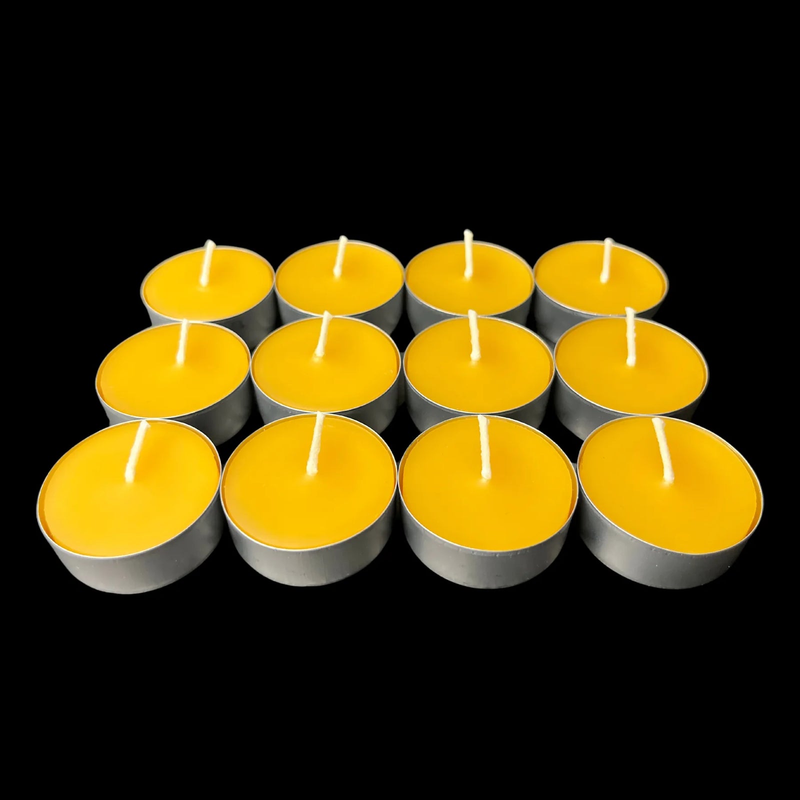 Golden yellow beeswax tea lights in aluminum cups in a small grid, 100% beeswax