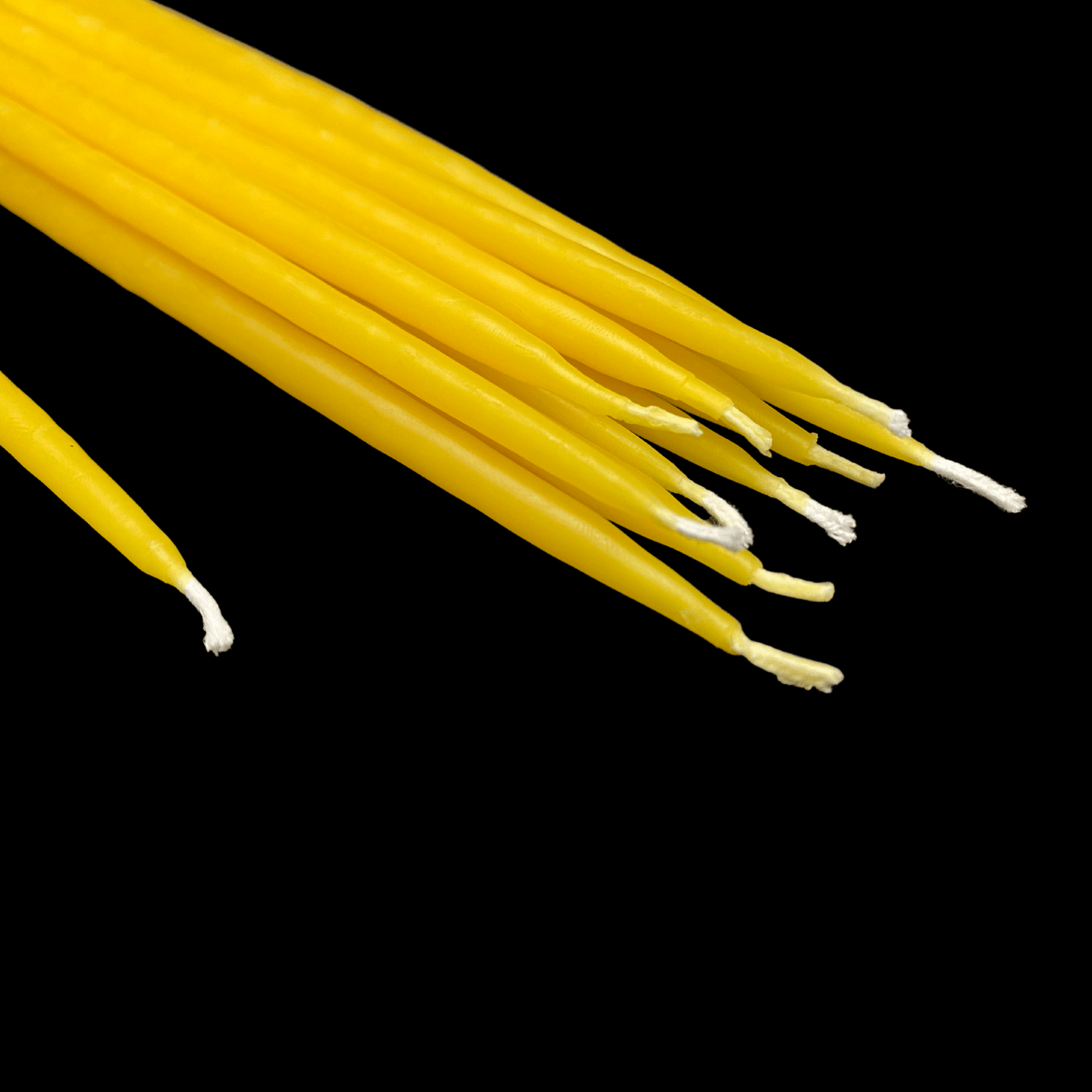 Yellow beeswax birthday taper candles laid flat made with 100% pure beeswax