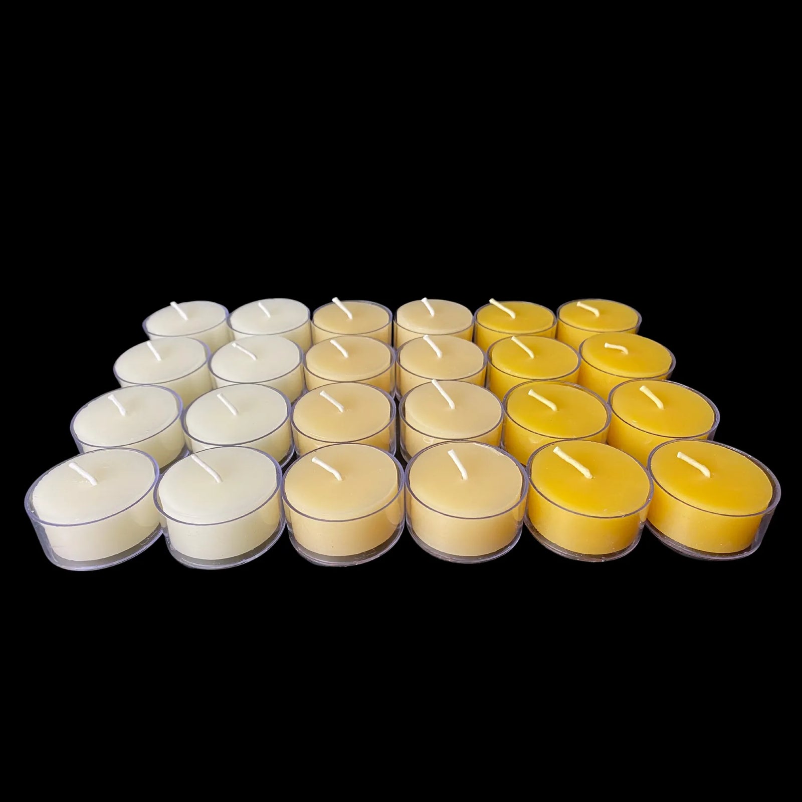 Assorted beeswax tea lights in clear cups arranged in rows, set of 24, cotton wick