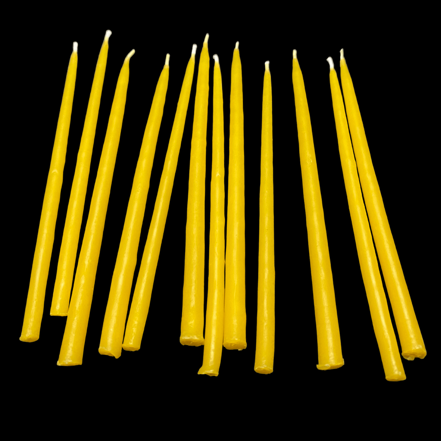Yellow beeswax birthday candles 6" thin tapers leaning together with cotton wicks