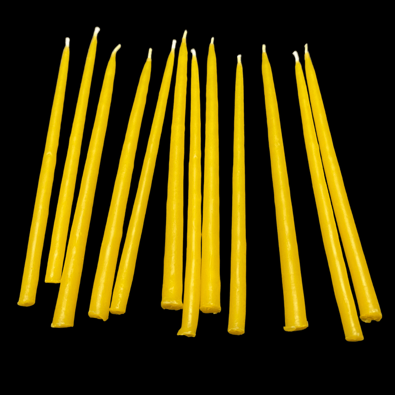 Yellow beeswax birthday candles 6" thin tapers leaning together with cotton wicks