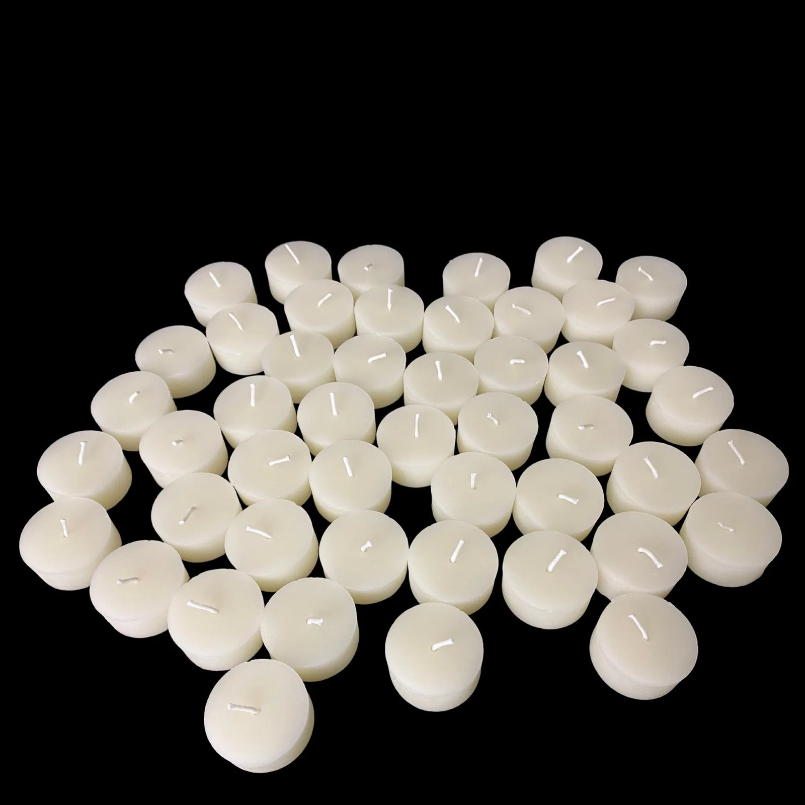 Cluster of white beeswax tea lights with some upright, cotton wick candles