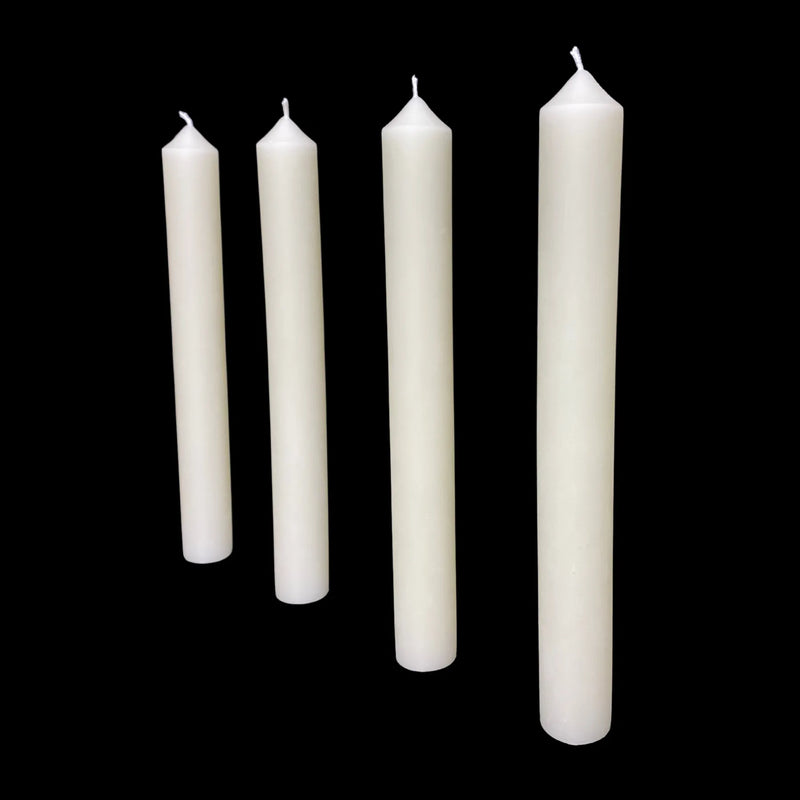 Four white dripless beeswax taper candles standing in a row, each 1" thick