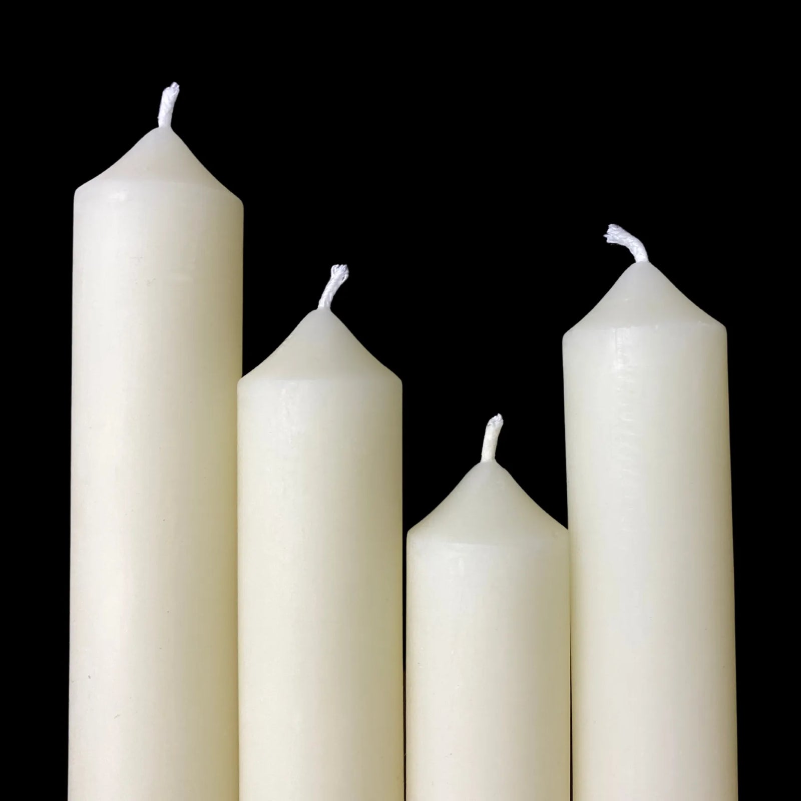 Assorted white beeswax taper candles standing together as a set, 1-inch thick