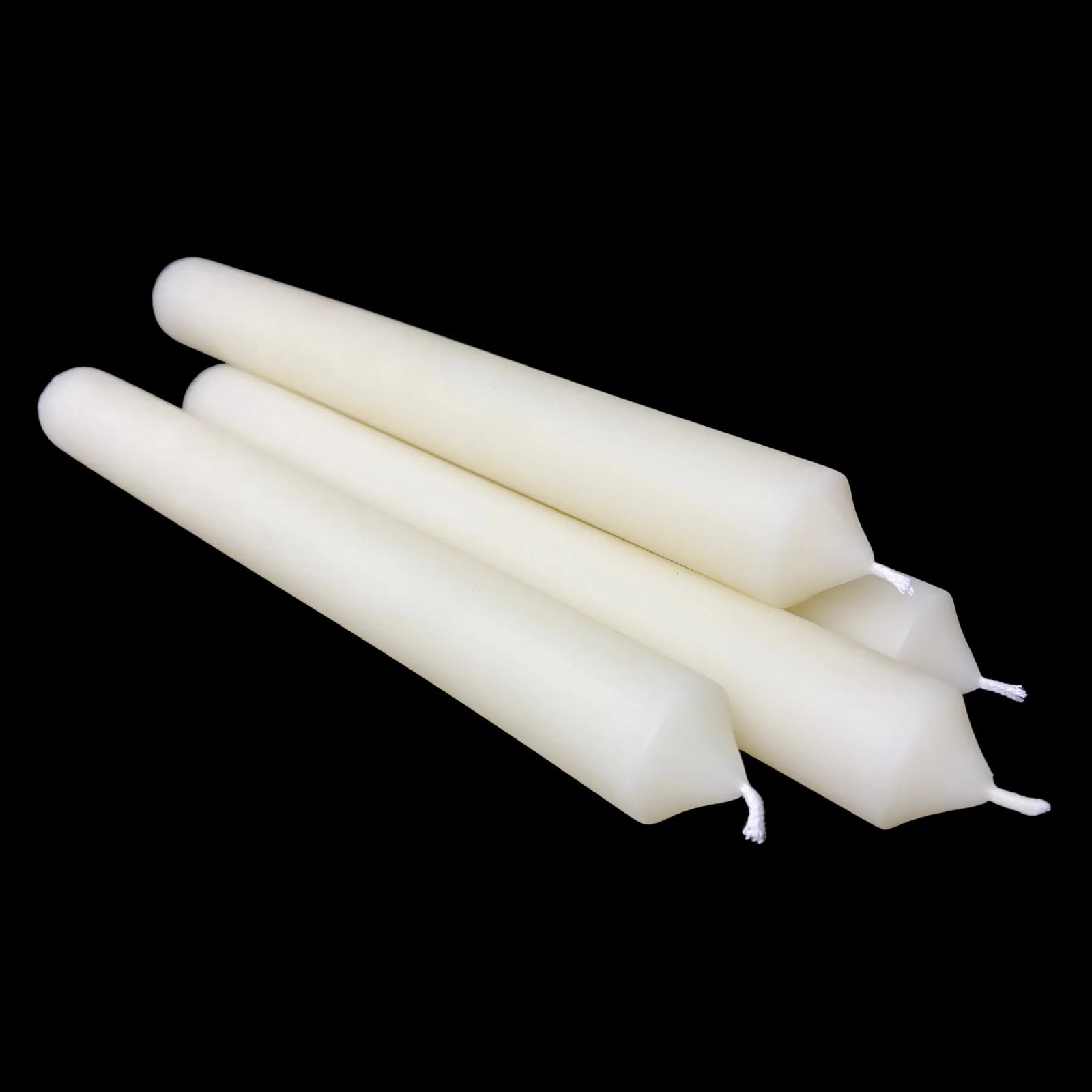 Four white beeswax dinner tapers crossed with cotton wicks facing front, one inch wide