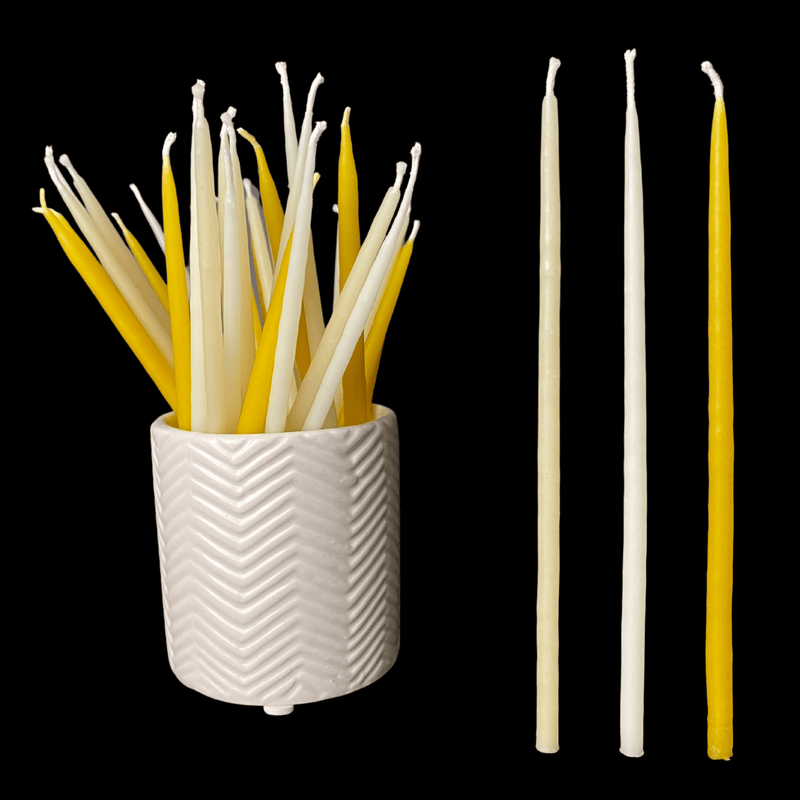 Yellow beeswax birthday taper candles with white and cappings beeswax in ceramic vessel
