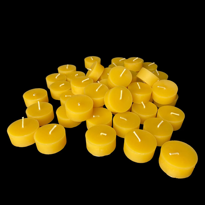 Small heap of yellow beeswax tea lights showing cotton wicks, 1.43 inch