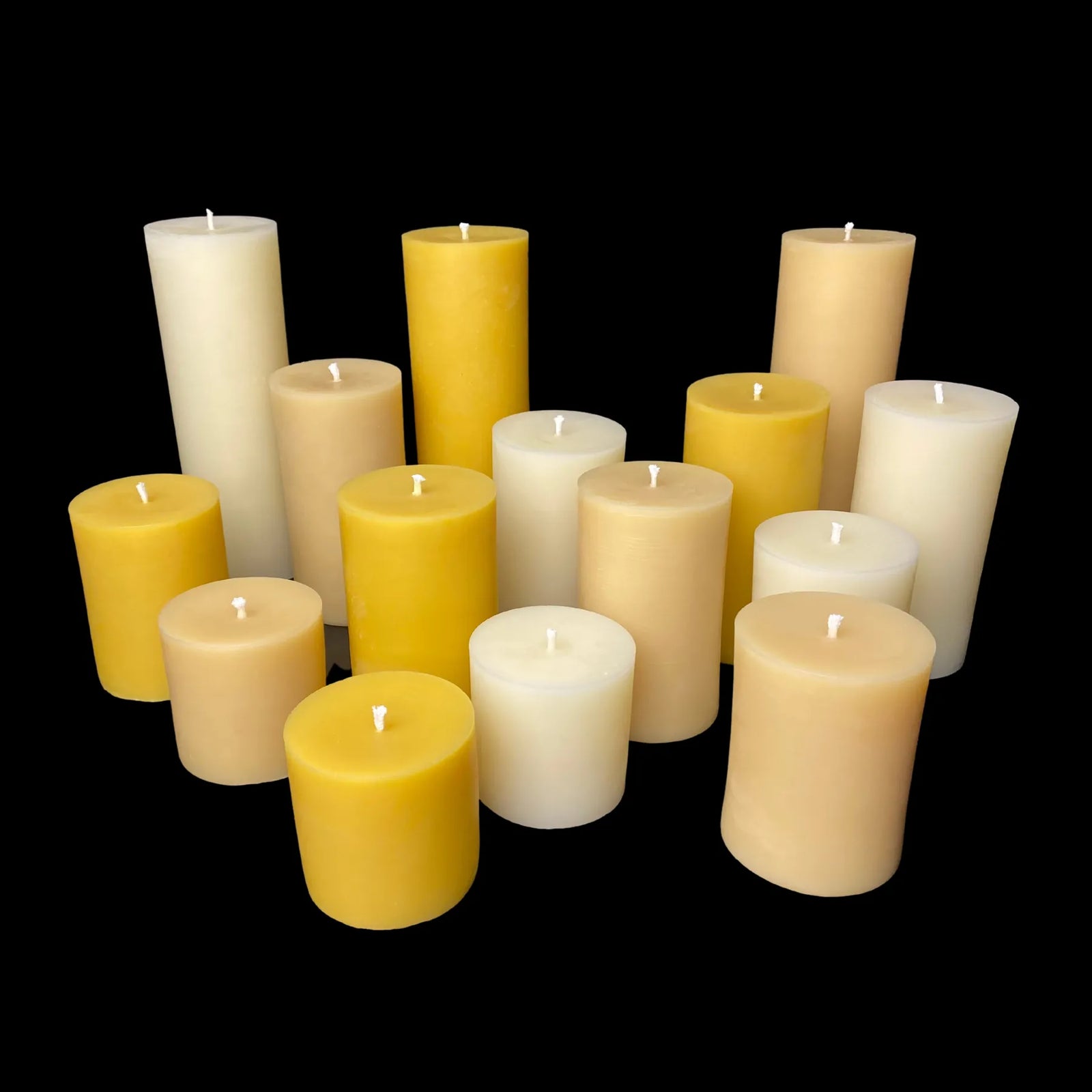 Handmade 100% beeswax pillar candles in yellow, beige, and white hues, ideal for weddings and events.