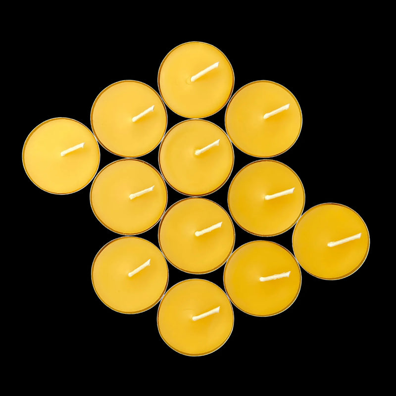 Saturated yellow beeswax tea lights in aluminum cups in a rounded cluster, hand poured